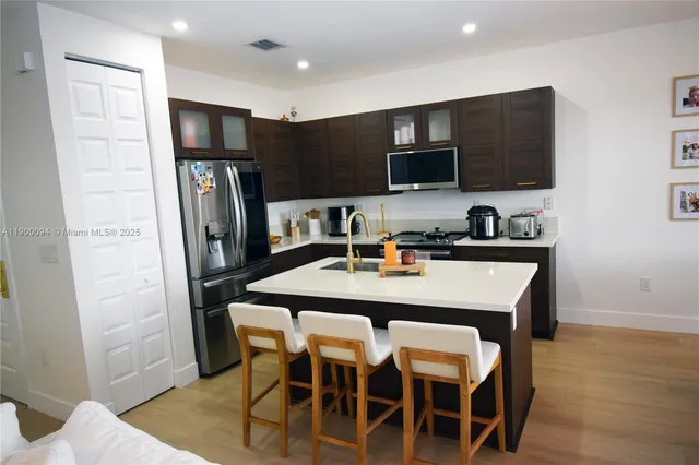 a kitchen with stainless steel appliances a refrigerator and a stove top oven
