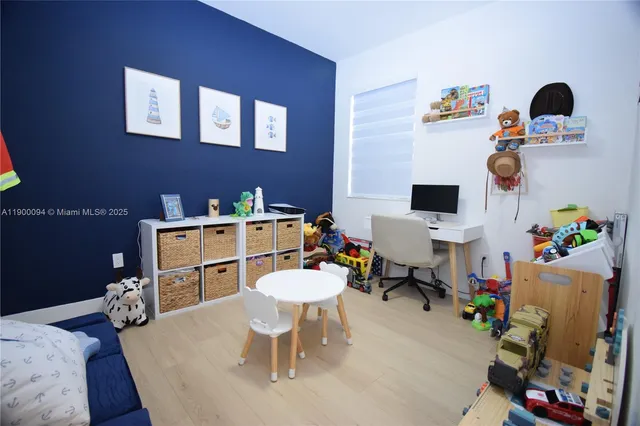 a bedroom with bed and a flat tv screen on dresser