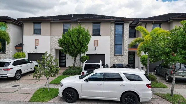 a view of a brick house with a small yard and deck