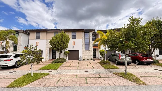 a view of a patio with table and chairs potted plants and a large tree