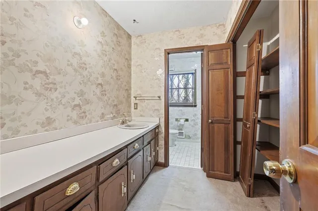 a bathroom with a double vanity sink a toilet and a shower