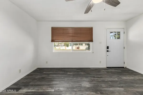 an empty room with wooden floor and windows