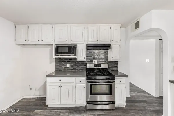 a kitchen with white cabinets and stainless steel appliances