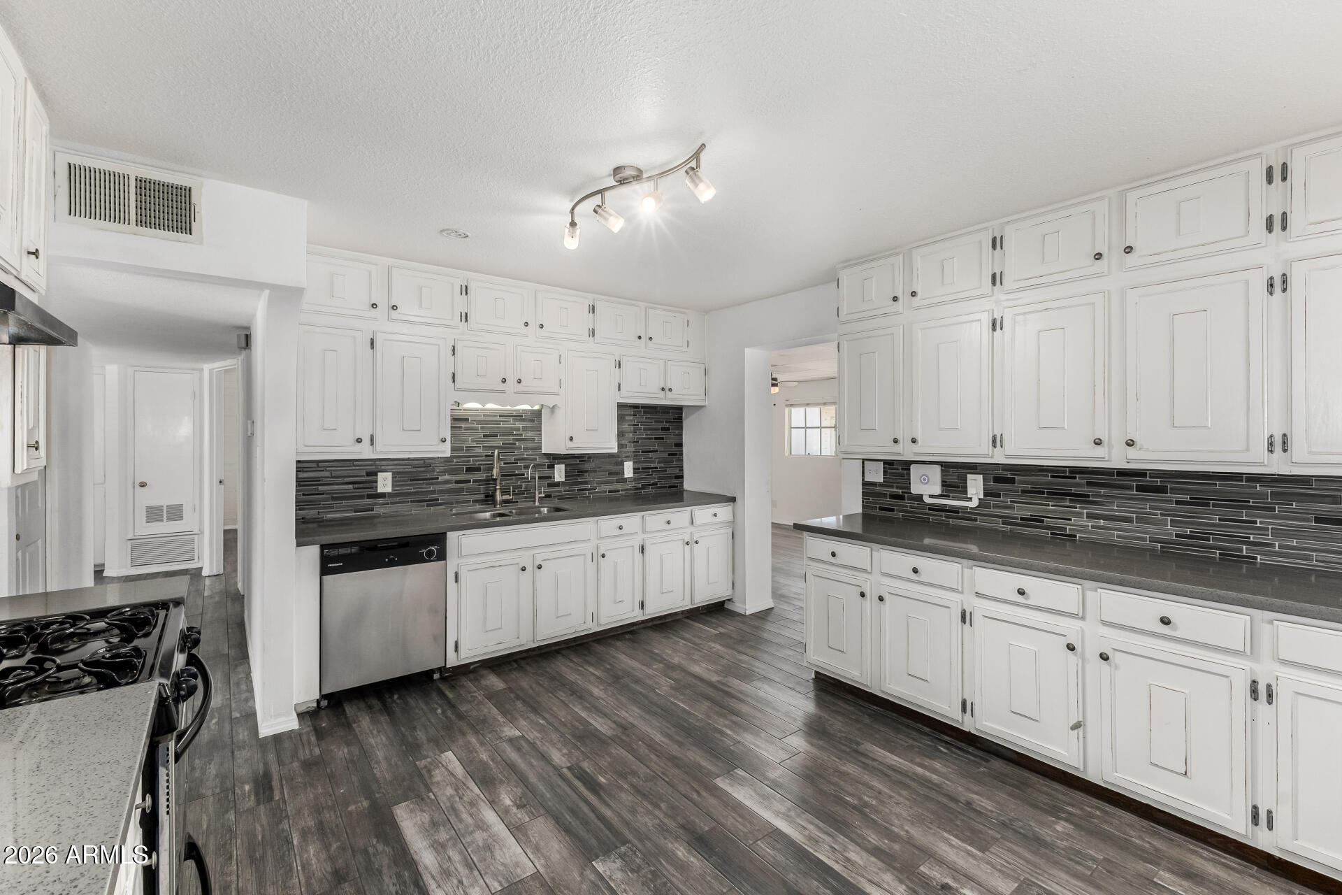 801 East Ruth Avenue Phoenix, AZ 85020 - Photo 7 of 35 a kitchen with granite countertop white cabinets a sink dishwasher and a stove with wooden floor
