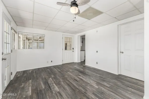 a view of empty room with wooden floor and ceiling fan