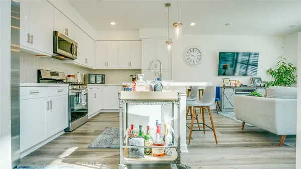 a kitchen with stainless steel appliances a stove a sink and a refrigerator