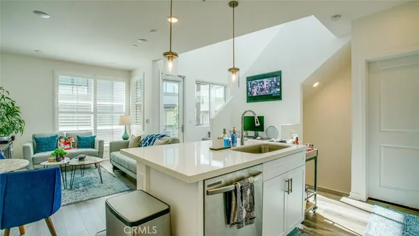 a kitchen with stainless steel appliances granite countertop a sink a stove a refrigerator cabinets and chairs