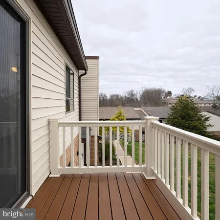 a view of wooden balcony with two chairs and wooden floor