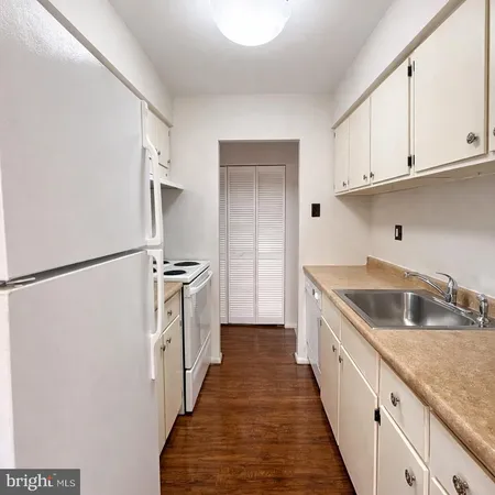 a kitchen with a sink a refrigerator and cabinets