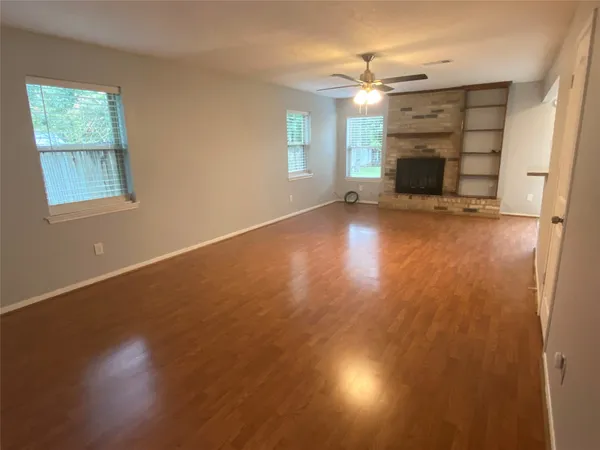 an empty room with windows and fireplace