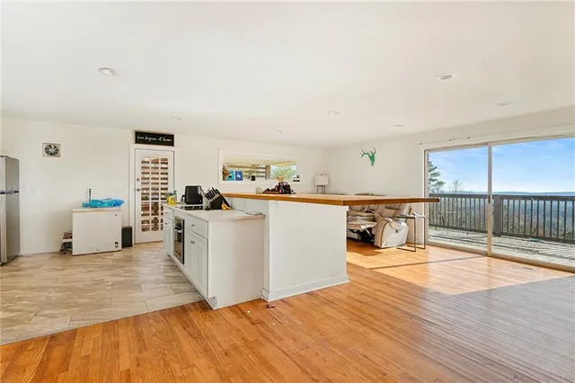 a living room with stainless steel appliances kitchen island granite countertop a sink and cabinets