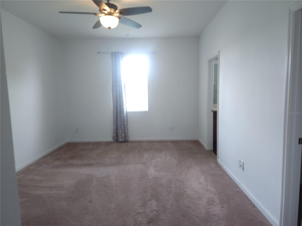 3230 Stratton Circle Kissimmee, FL 34744 - Photo 14 of 28 an empty room with a window and a fan