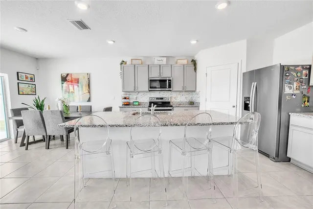 a kitchen with stainless steel appliances granite countertop a refrigerator and a sink
