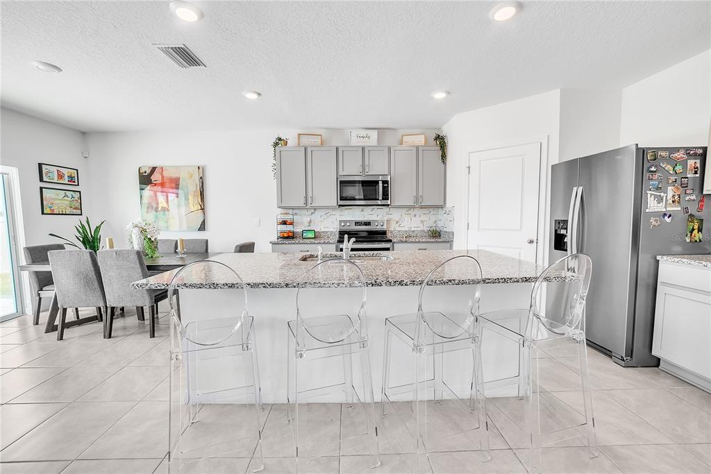 8237 Juning Cove Wesley Chapel, FL 33545 - Photo 14 of 59 a kitchen with stainless steel appliances a refrigerator sink and cabinets