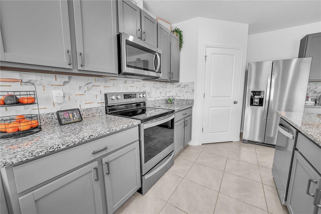 8237 Juning Cove Wesley Chapel, FL 33545 - Photo 18 of 59 a kitchen with stainless steel appliances granite countertop a refrigerator and a sink