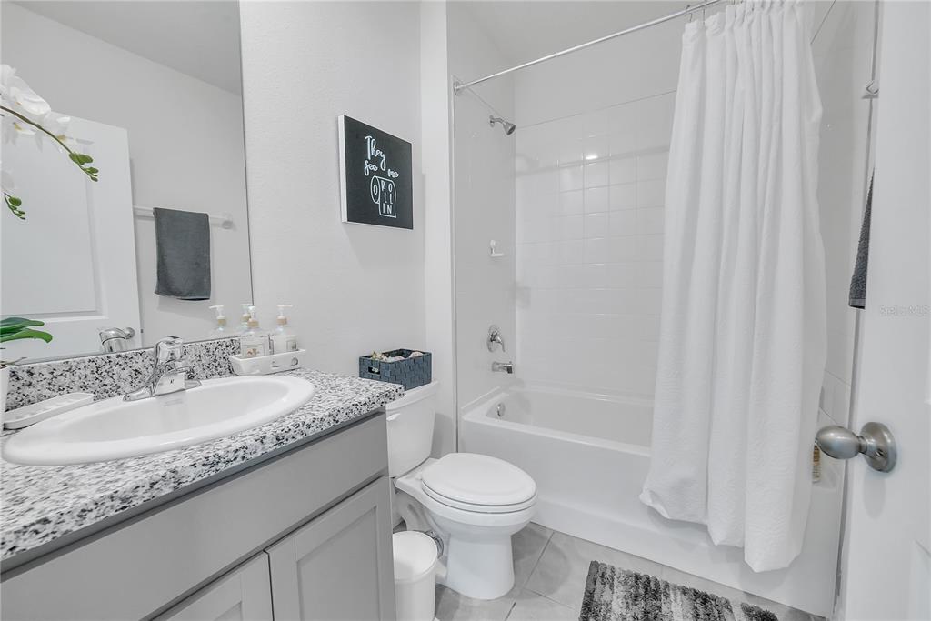 8237 Juning Cove Wesley Chapel, FL 33545 - Photo 25 of 59 a bathroom with a granite countertop sink toilet and shower