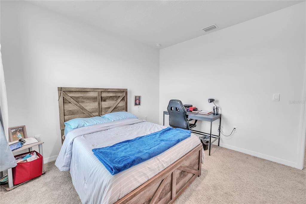 8237 Juning Cove Wesley Chapel, FL 33545 - Photo 42 of 59 a bedroom with a bed and a table in it