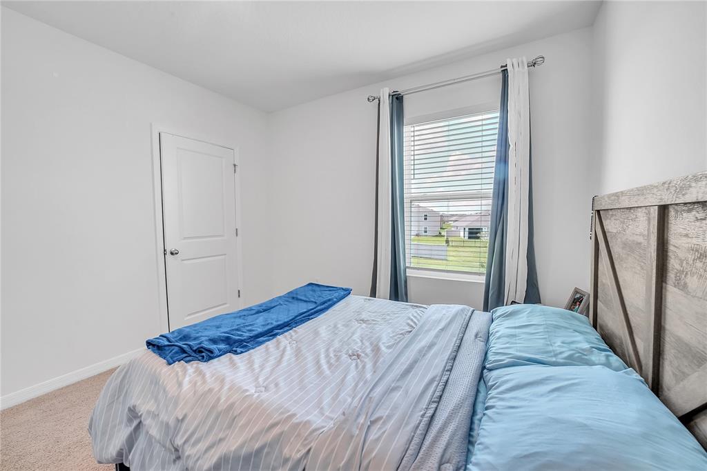 8237 Juning Cove Wesley Chapel, FL 33545 - Photo 43 of 59 a bedroom with a bed and wooden floor