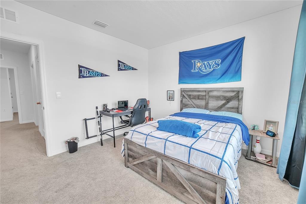 8237 Juning Cove Wesley Chapel, FL 33545 - Photo 45 of 59 a bedroom with a bed and a table in it
