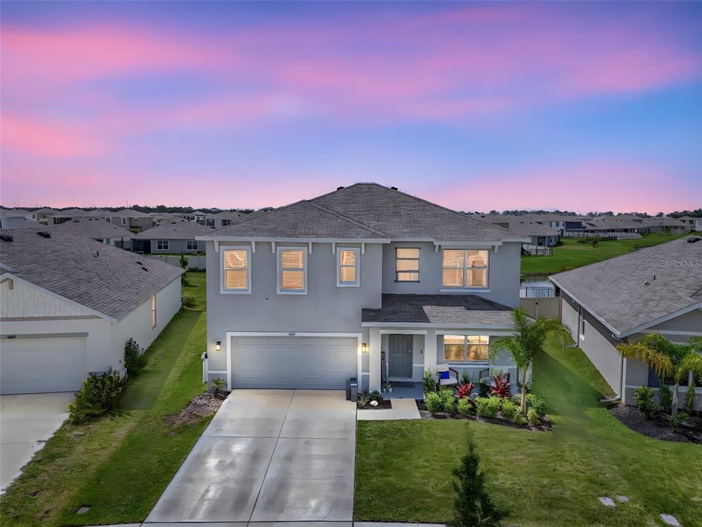 8237 Juning Cove Wesley Chapel, FL 33545 - Photo 50 of 59 a front view of a house with a yard and garage