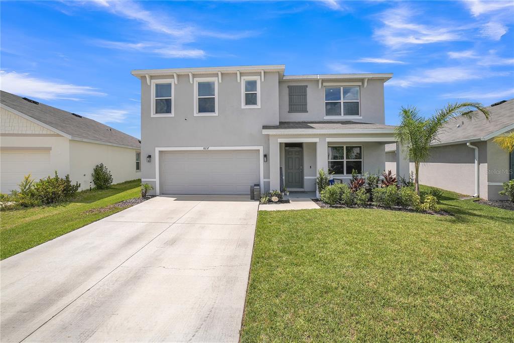 8237 Juning Cove Wesley Chapel, FL 33545 - Photo 5 of 59 a front view of a house with garden