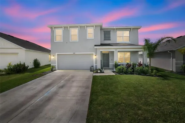 an aerial view of a house with a garden and lake view