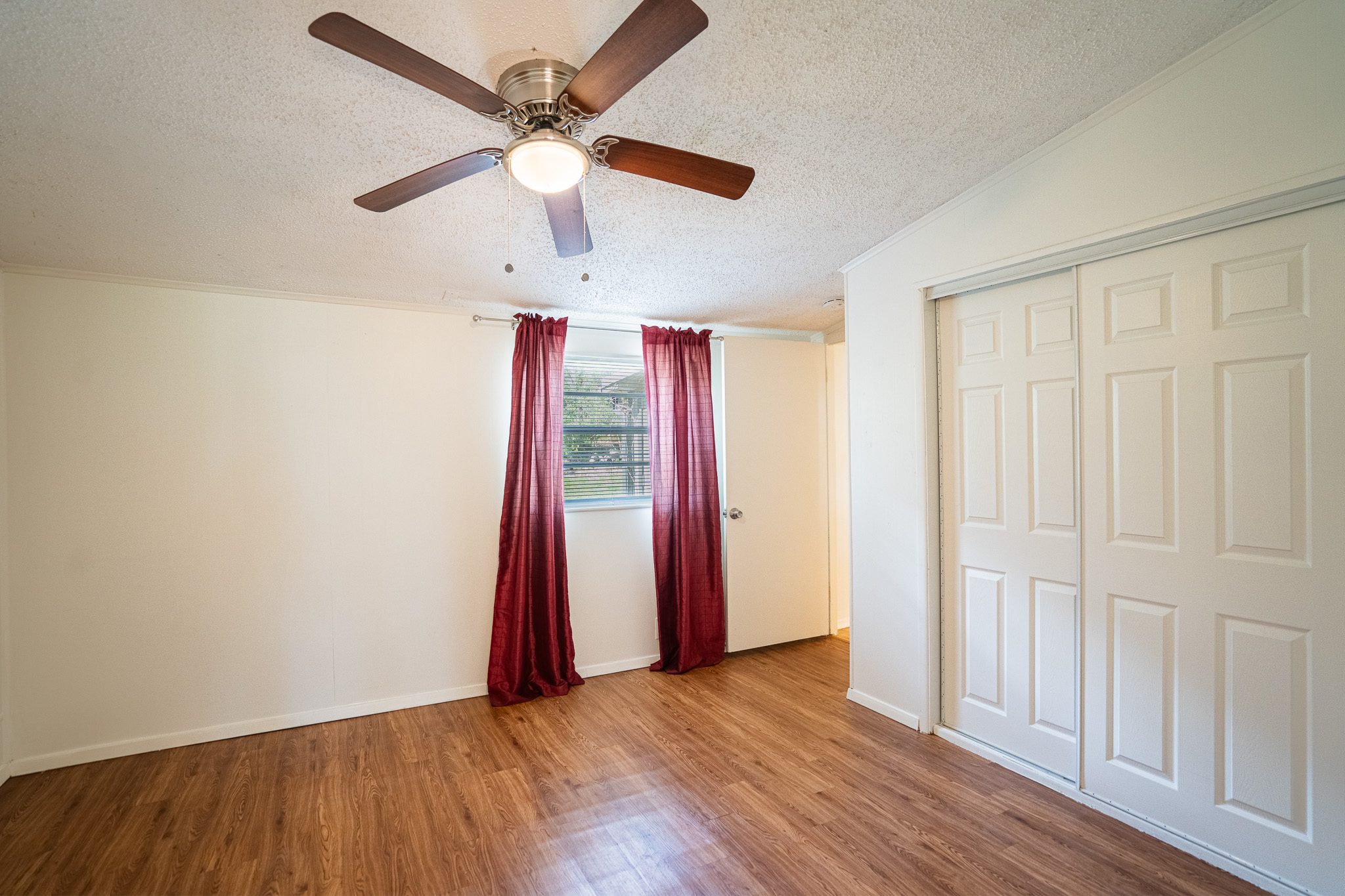16013 Edwards Drive Austin, TX 78734 - Photo 16 of 18 Bright bedroom space featuring polished hardwood floors and a convenient ceiling fan for year-round comfort.