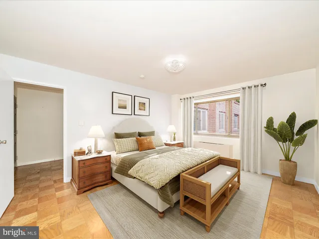 a bedroom with a bed lamp and a potted plant