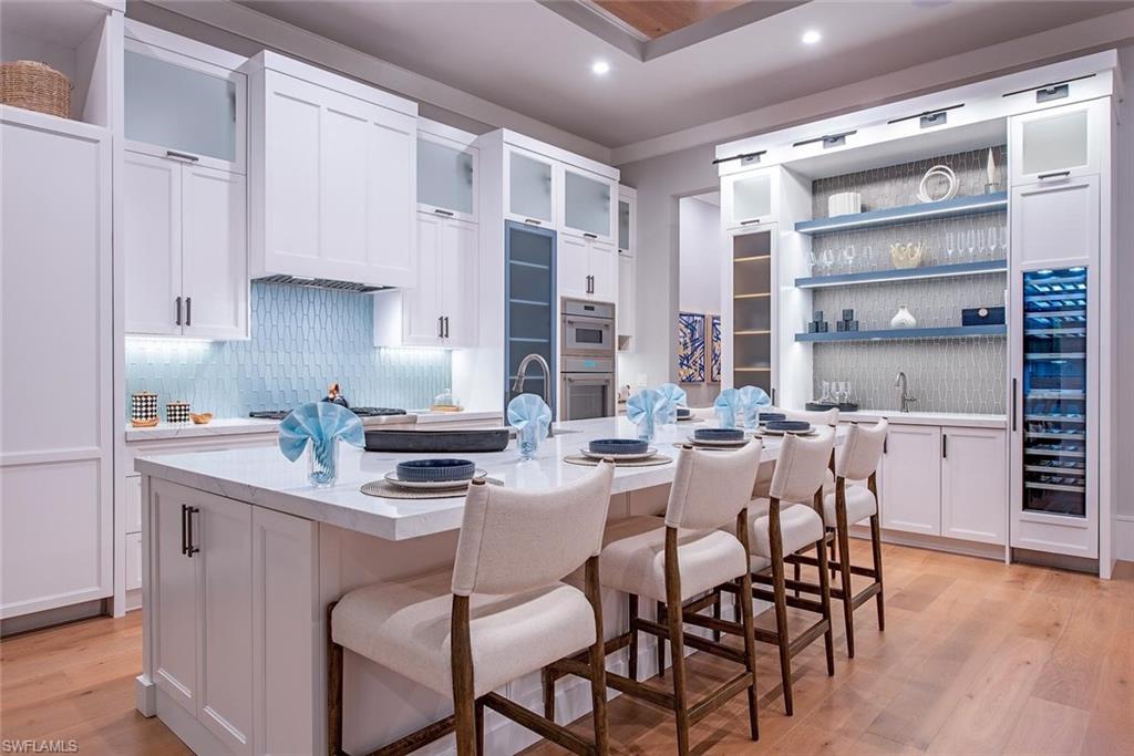 1456 Curlew Avenue Naples, FL 34102 - Photo 9 of 38 a kitchen with a dining table chairs stainless steel appliances and cabinets