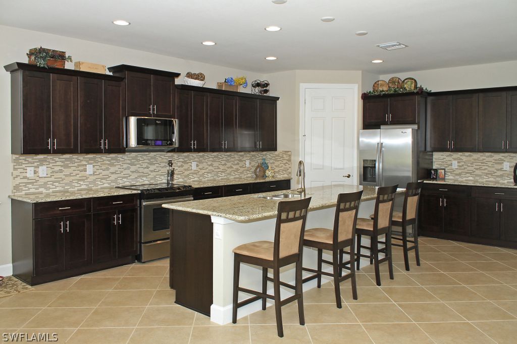 10874 Rutherford Road Fort Myers, FL 33913 - Photo 3 of 24 a kitchen with stainless steel appliances kitchen island granite countertop a sink and cabinets
