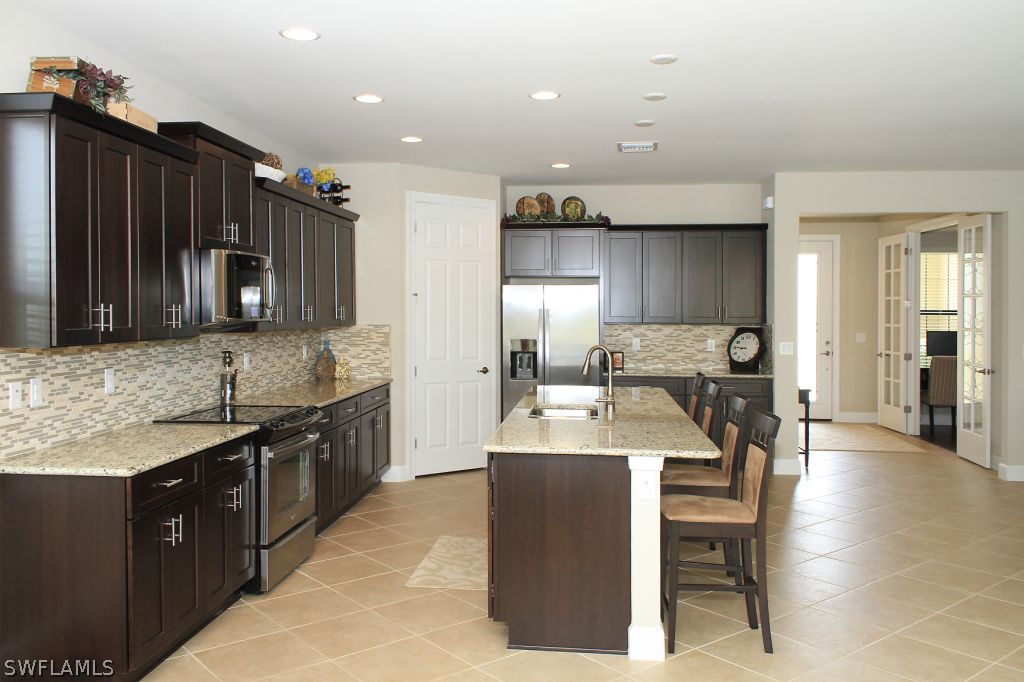 10874 Rutherford Road Fort Myers, FL 33913 - Photo 5 of 24 a kitchen with granite countertop a sink appliances and cabinets
