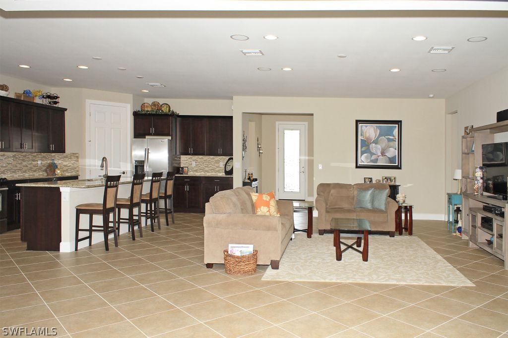 10874 Rutherford Road Fort Myers, FL 33913 - Photo 8 of 24 a living room with furniture a flat screen tv and kitchen view
