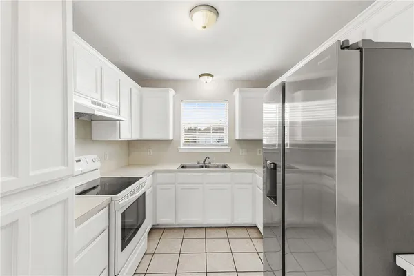 a kitchen with a sink a refrigerator and cabinets