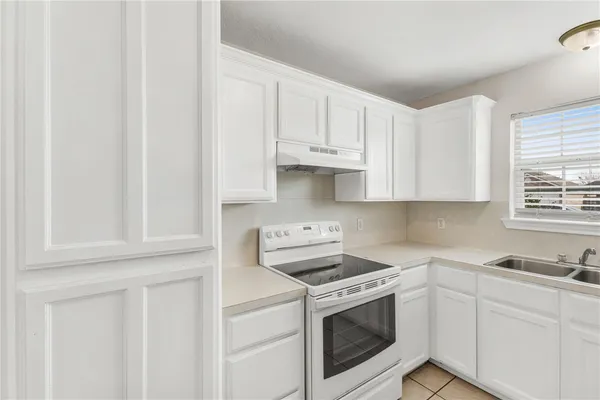 a kitchen with white cabinets and white appliances