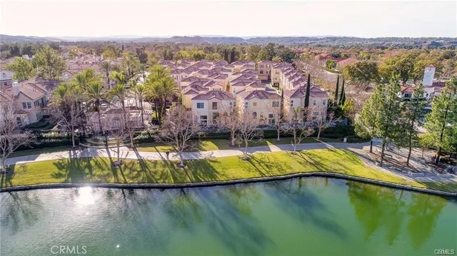 an aerial view of a house with a garden and lake view