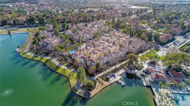 an aerial view of residential houses with outdoor space and trees