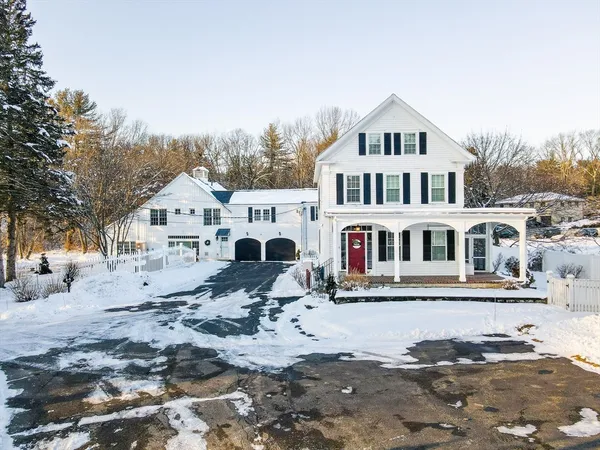 a view of a white house with a yard covered in snow