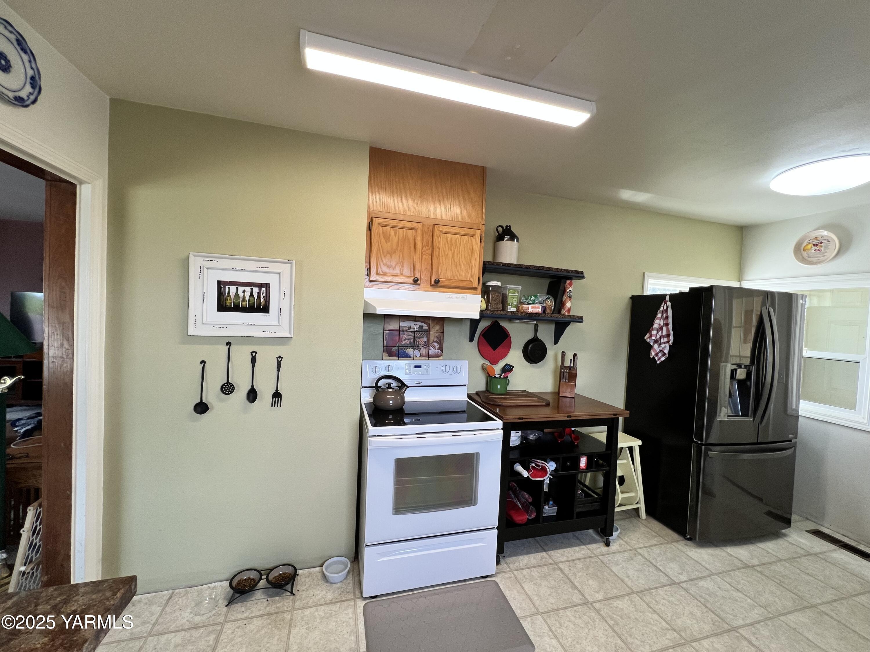 960 Knight Hill Road Zillah, WA 98953 - Photo 14 of 21 a view of a kitchen with fridge and workspace