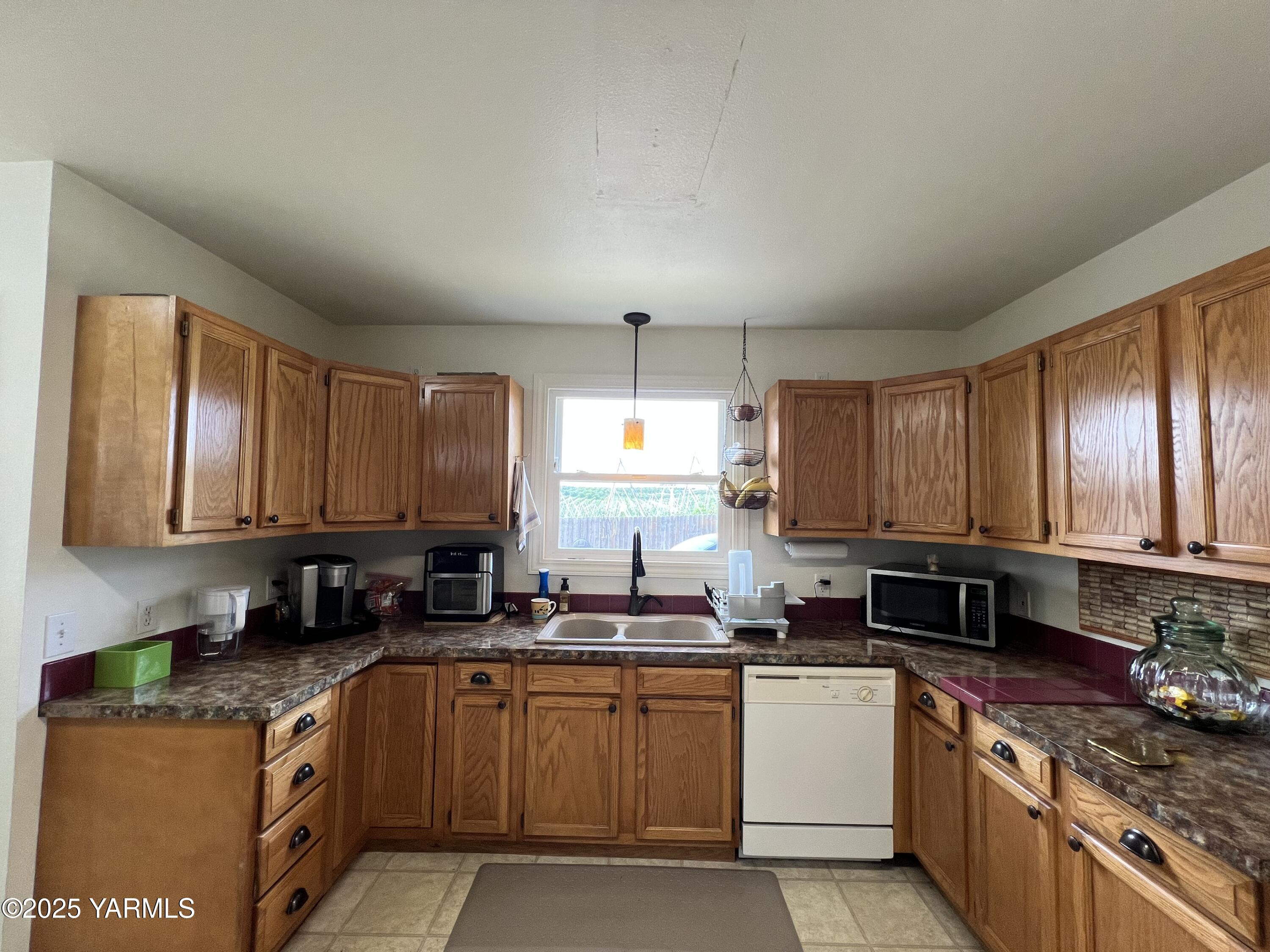 960 Knight Hill Road Zillah, WA 98953 - Photo 15 of 21 a kitchen with granite countertop a sink a counter top space appliances and cabinets