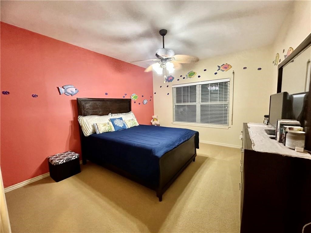 39 Front Street Rockport, TX 78382 - Photo 18 of 38 a spacious bedroom with a bed and a chandelier