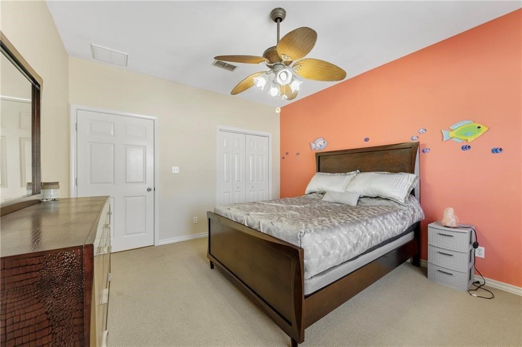 39 Front Street Rockport, TX 78382 - Photo 19 of 38 a bedroom with a bed and a chandelier