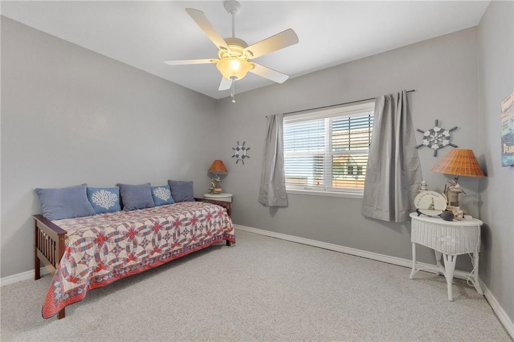 39 Front Street Rockport, TX 78382 - Photo 20 of 38 a bedroom with a bed and a chandelier