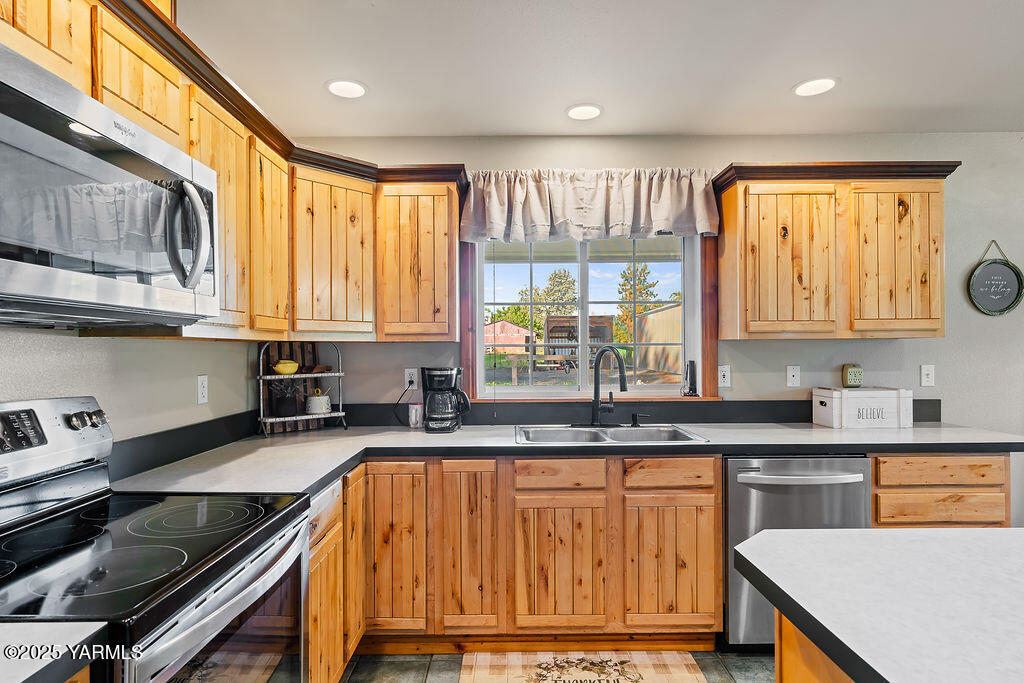 790 Cook Road Yakima, WA 98908 - Photo 9 of 46 a kitchen with stainless steel appliances granite countertop a sink a stove cabinets counter space and a window
