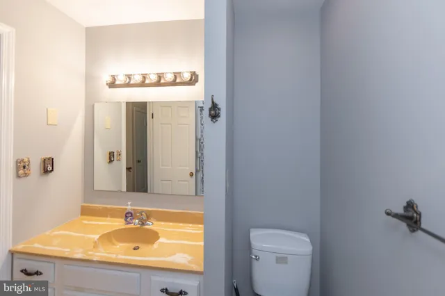 a bathroom with a sink and mirror with toilet
