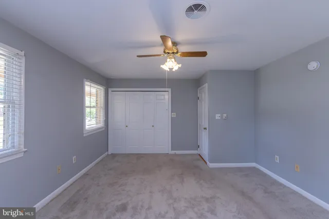 a view of a room with a ceiling fan and a window