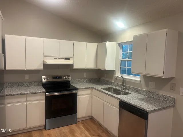a kitchen with a sink stove and cabinets