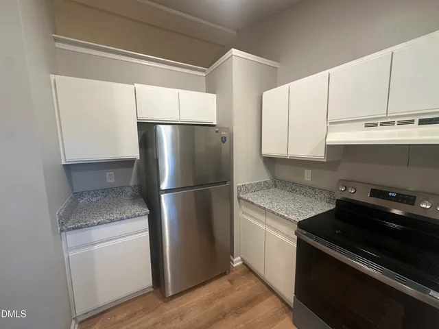 a kitchen with a refrigerator stove and cabinets