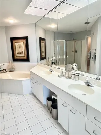 a bathroom with a double vanity sink mirror and bathtub