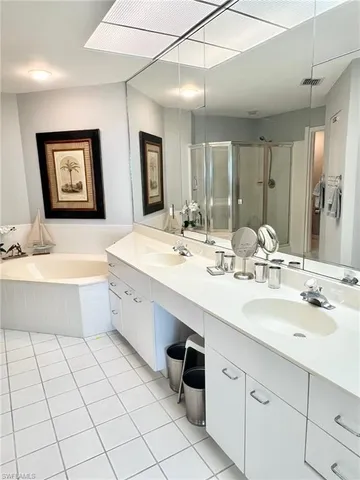 a bathroom with a double vanity sink mirror and bathtub