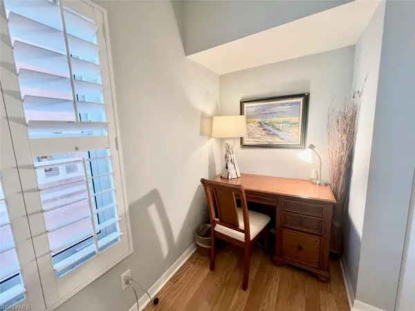 a view of a workspace with furniture and wooden floor